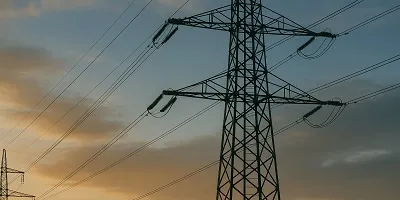 Energy & Utilities Industry Icon Energy & Utilities industry visual for Tier2Tek Staffing, featuring high-voltage electrical power lines and transmission towers silhouetted against a sunset sky.