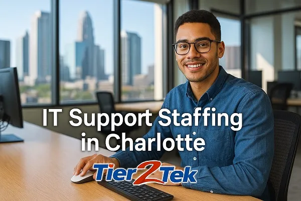 IT support professional at a desk with Charlotte skyline in the background – Tier2Tek Staffing