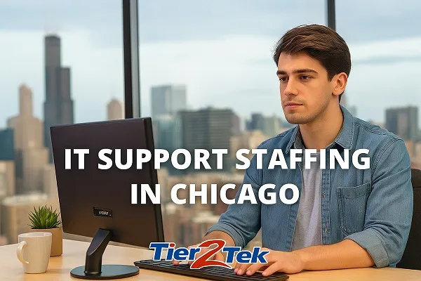Young IT support professional working at a desk with Chicago skyline in the background, representing Tier2Tek Staffing’s IT support staffing services.