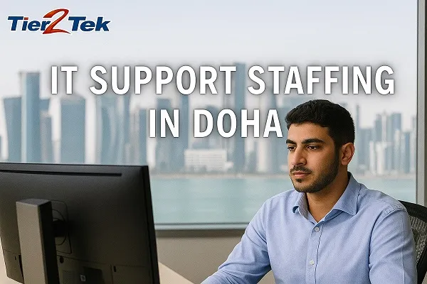 Arab IT support professional working in an office with the Doha skyline in the background, promoting Tier2Tek Staffing’s services.