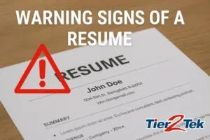 Image of a printed resume on a wooden desk with a red warning sign icon, bold text reading ‘Warning Signs of a Resume,’ and the Tier2Tek Staffing logo in the corner.