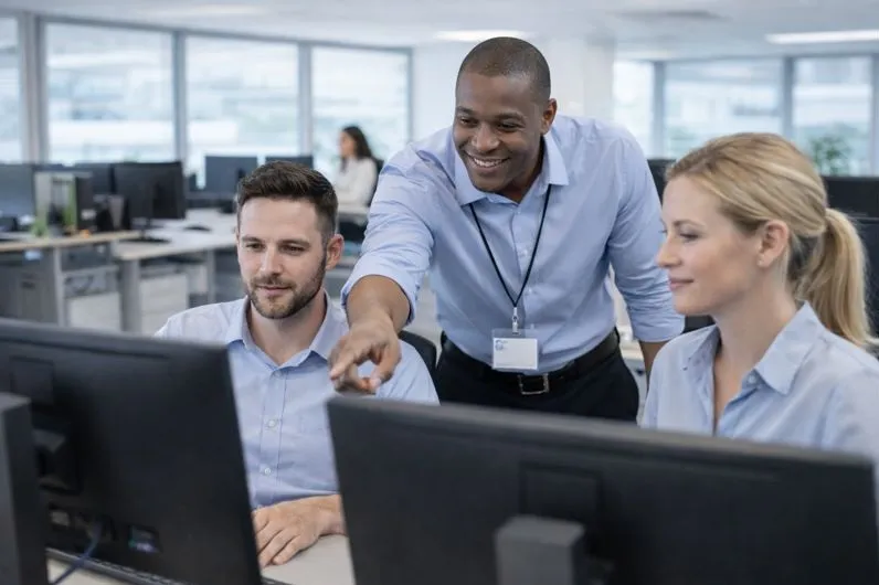 IT support technician assisting multiple employees with desktop support in an office environment